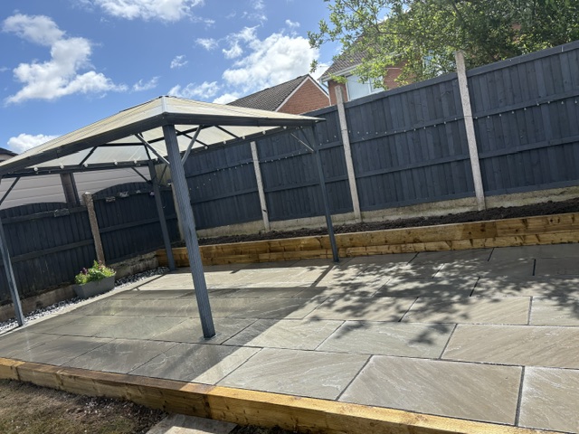Patio with pergola and raised sleeper border — completed project